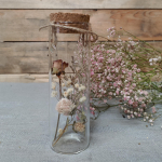 een met droogbloemen gevuld glazen buisje